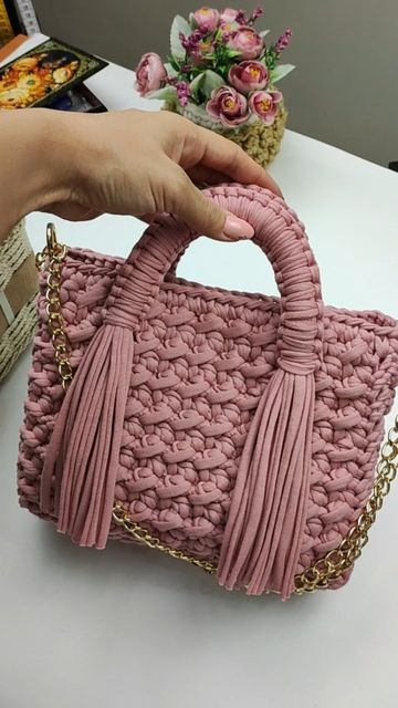 Bolso rosa tejido en trapillo con asas, borlas y cadena dorada